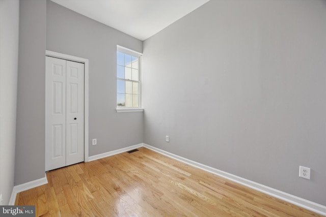 unfurnished bedroom with light hardwood / wood-style floors and a closet