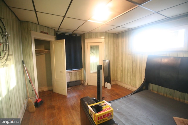 bedroom with a paneled ceiling, dark hardwood / wood-style flooring, and a closet