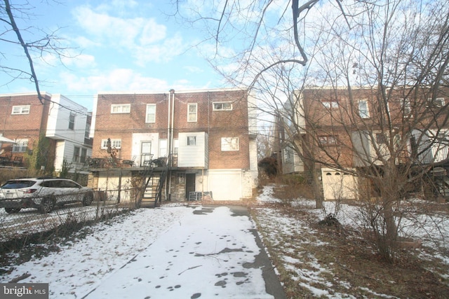 view of snow covered back of property