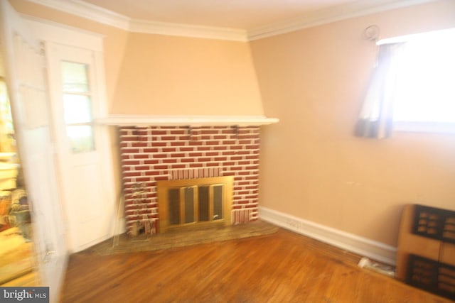 unfurnished living room featuring hardwood / wood-style floors, crown molding, and a fireplace