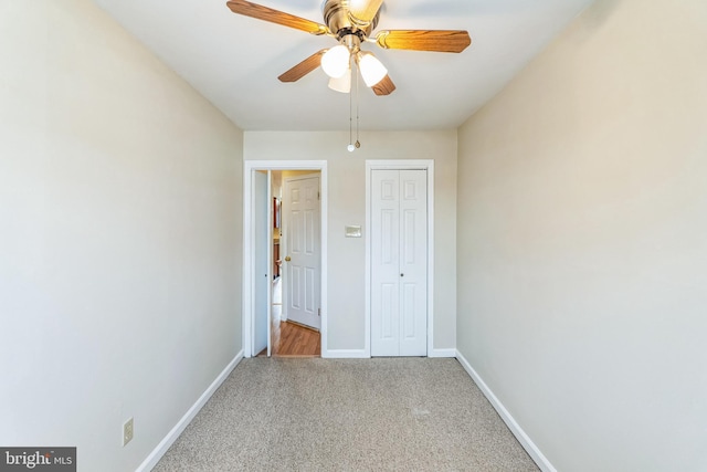 unfurnished bedroom featuring ceiling fan, light carpet, and a closet