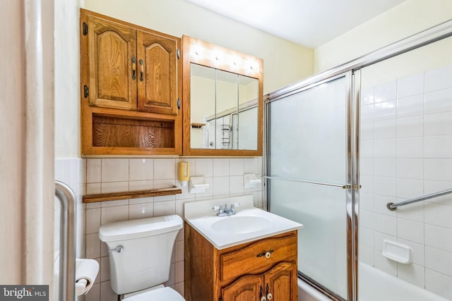 full bathroom with vanity, shower / bath combination with glass door, toilet, tile walls, and tasteful backsplash