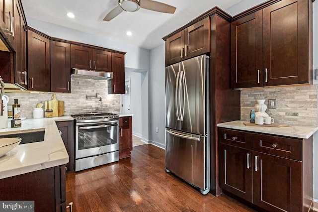 kitchen featuring backsplash, light stone counters, stainless steel appliances, and dark hardwood / wood-style floors