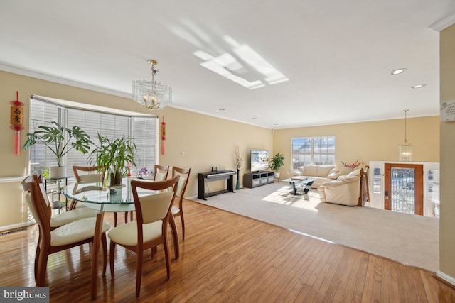 dining area with light hardwood / wood-style floors and crown molding