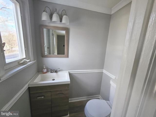 bathroom featuring ornamental molding, vanity, toilet, and hardwood / wood-style floors