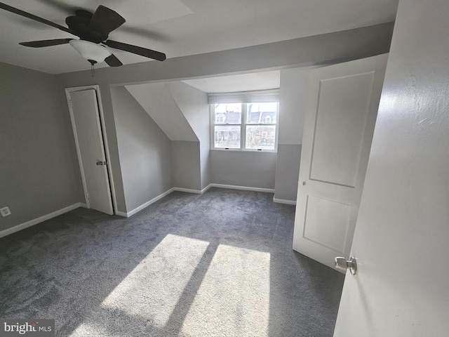 additional living space with ceiling fan and dark colored carpet