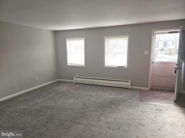 carpeted spare room featuring plenty of natural light and baseboard heating