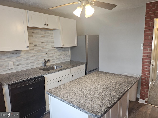 kitchen with white cabinetry, black dishwasher, sink, and stainless steel refrigerator