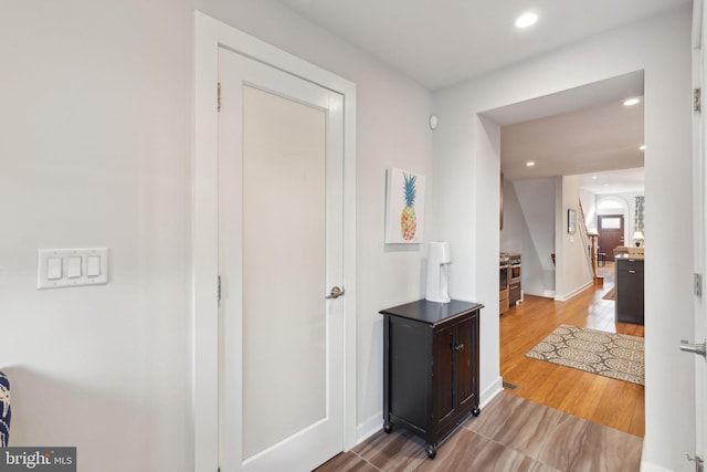 hall with hardwood / wood-style flooring