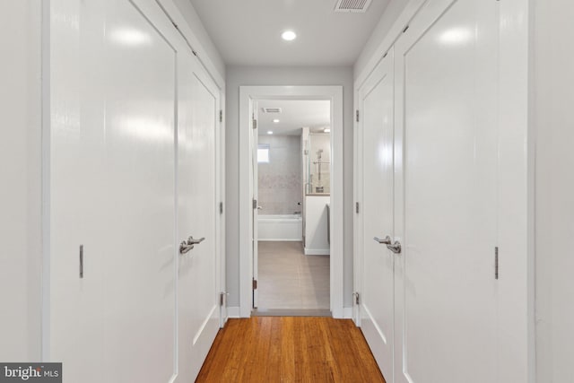 corridor with hardwood / wood-style flooring