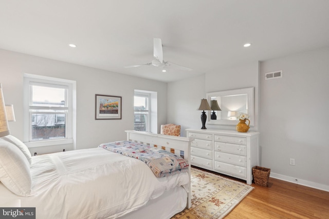 bedroom featuring multiple windows, ceiling fan, and light hardwood / wood-style flooring