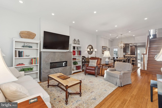 living room featuring light hardwood / wood-style floors and a tiled fireplace