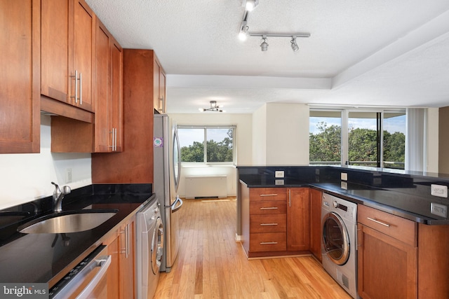 kitchen with washer / clothes dryer, sink, stainless steel appliances, and a textured ceiling