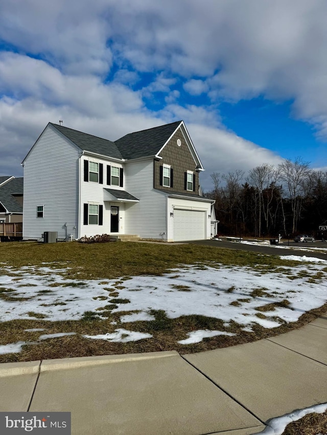 view of property with a garage and central air condition unit