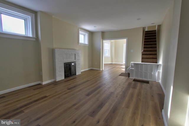 unfurnished living room featuring a fireplace and dark hardwood / wood-style floors