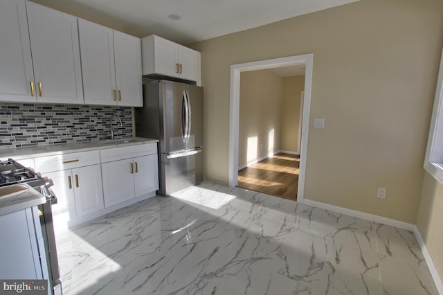 kitchen with decorative backsplash, sink, white cabinetry, and stainless steel appliances