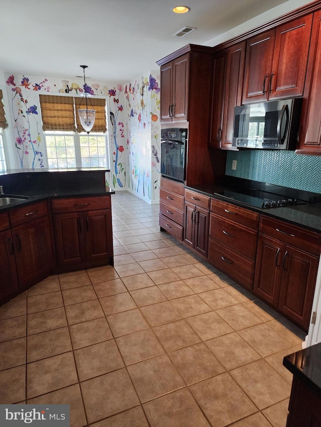 kitchen with light tile patterned floors, a sink, visible vents, black appliances, and decorative light fixtures