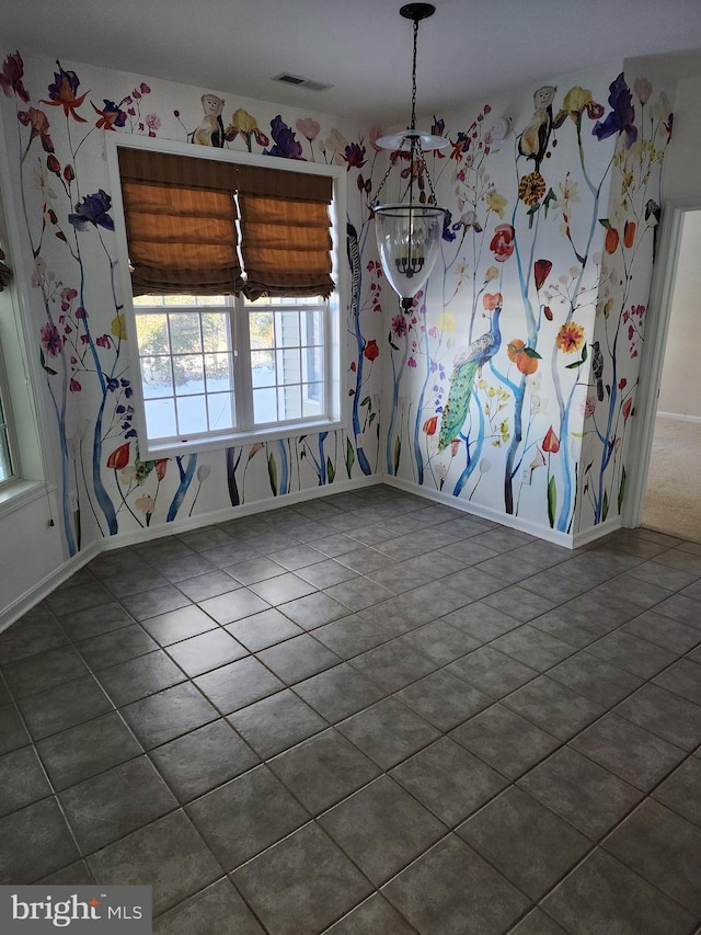 unfurnished dining area with baseboards and visible vents