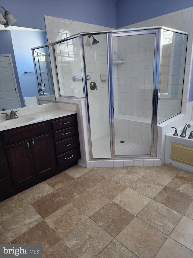 bathroom with stone finish flooring, a garden tub, a shower stall, and vanity