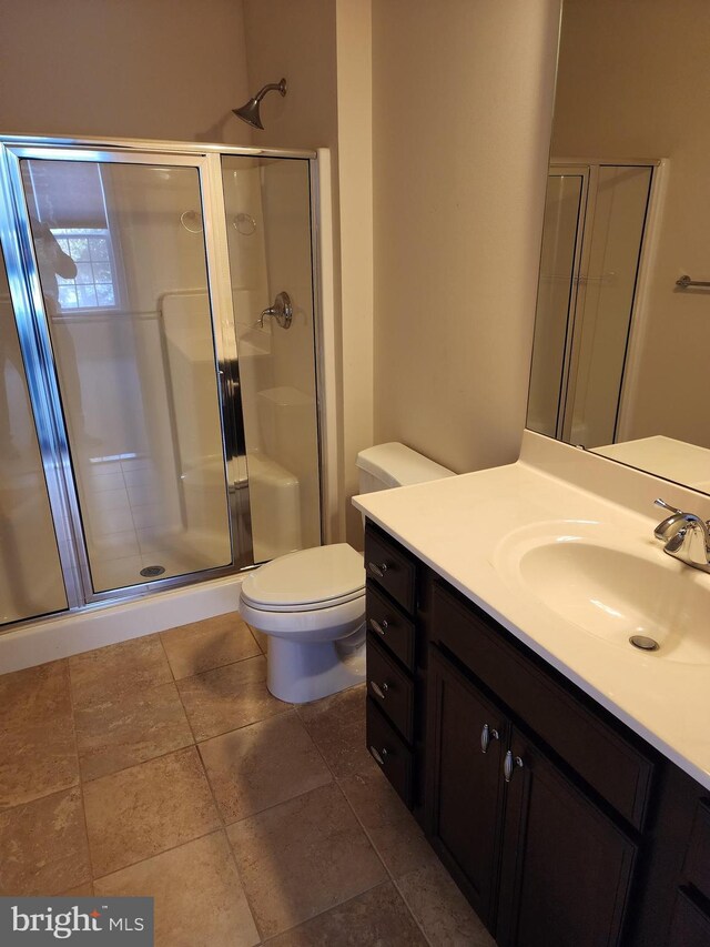 bathroom with a stall shower, vanity, and toilet