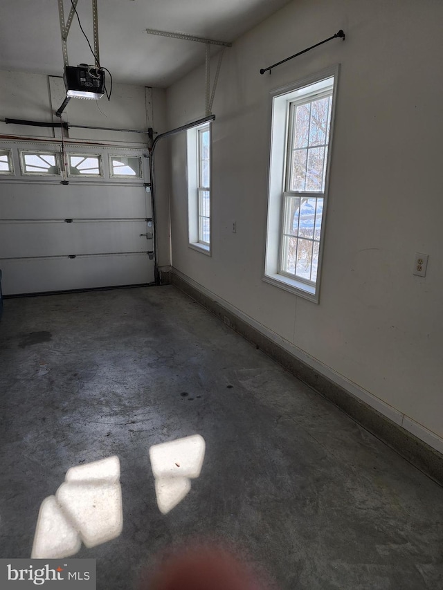 garage featuring a garage door opener and baseboards