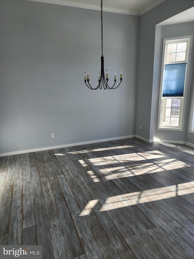 unfurnished dining area with dark wood-style floors, a notable chandelier, baseboards, and ornamental molding