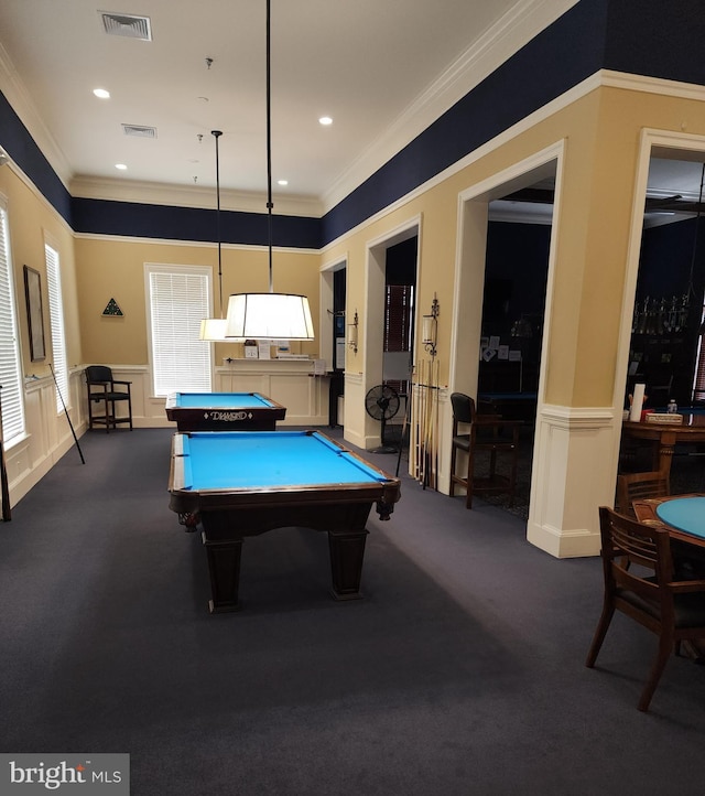 recreation room with a wainscoted wall, ornamental molding, and visible vents