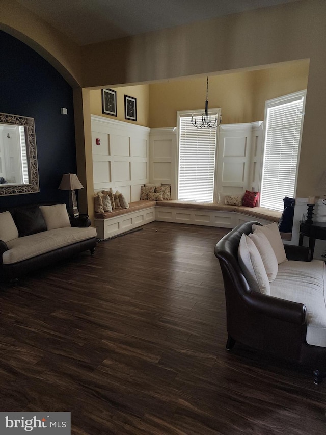 living area with dark wood finished floors and a notable chandelier