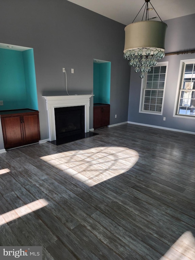 unfurnished living room with a fireplace with flush hearth, baseboards, and dark wood-style floors