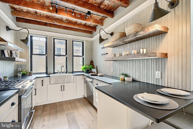 kitchen with sink, light hardwood / wood-style flooring, beamed ceiling, white cabinetry, and stainless steel appliances