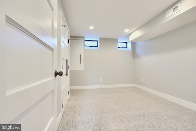 basement featuring light colored carpet