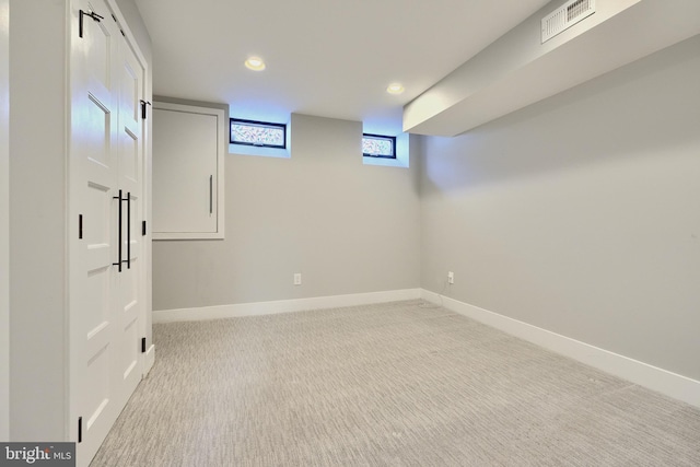 basement featuring light carpet