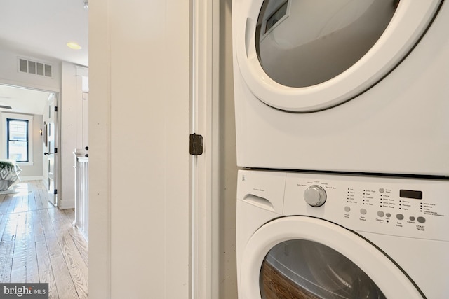 washroom featuring wood-type flooring and stacked washer and dryer