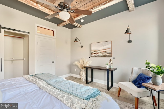 bedroom featuring beamed ceiling, ceiling fan, light wood-type flooring, and wood ceiling