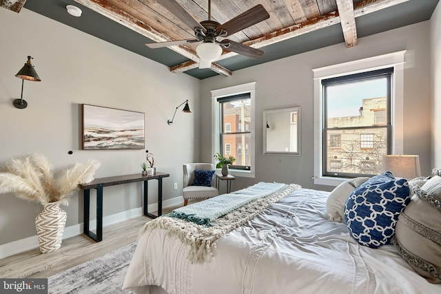 bedroom featuring ceiling fan, beamed ceiling, wooden ceiling, and light wood-type flooring