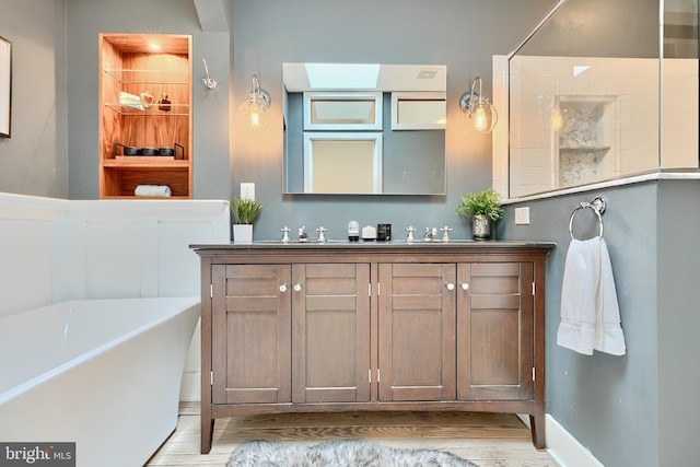 bathroom with a tub, vanity, and wood-type flooring