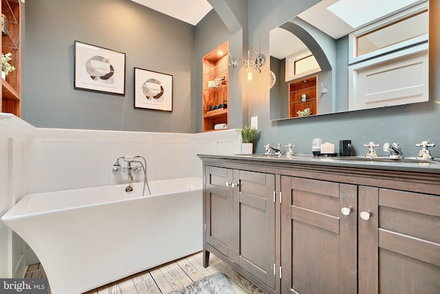 bathroom with a washtub, vanity, and hardwood / wood-style floors