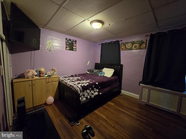 bedroom featuring dark hardwood / wood-style flooring and a drop ceiling