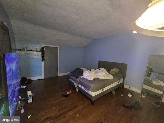 bedroom featuring hardwood / wood-style floors and vaulted ceiling