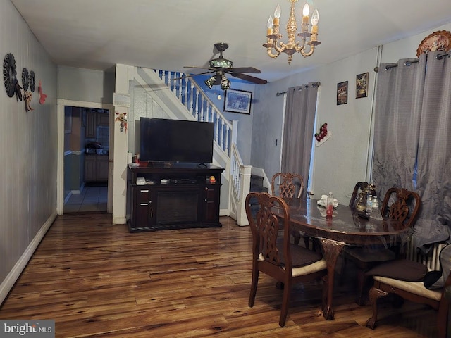 dining space with dark hardwood / wood-style floors and ceiling fan with notable chandelier