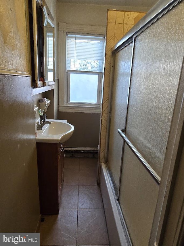 bathroom with tile patterned flooring, vanity, a shower with shower door, and plenty of natural light