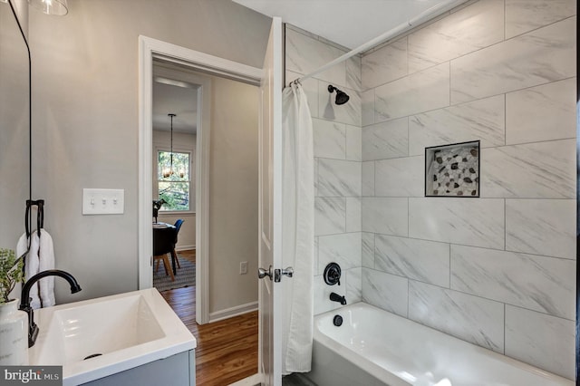 bathroom featuring sink, hardwood / wood-style flooring, an inviting chandelier, and shower / tub combo with curtain