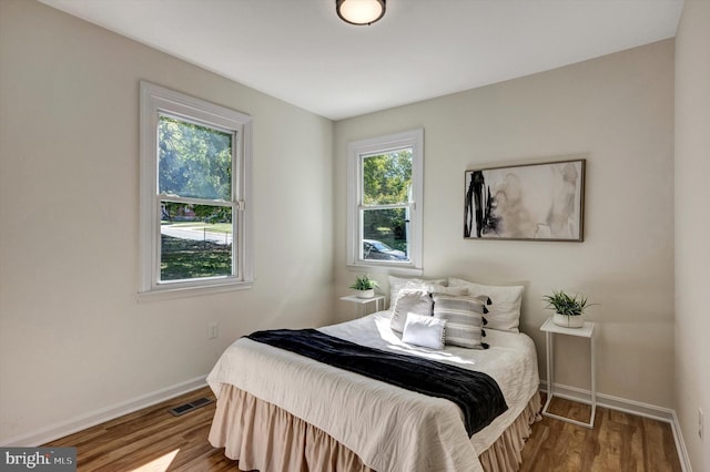 bedroom featuring wood-type flooring and multiple windows