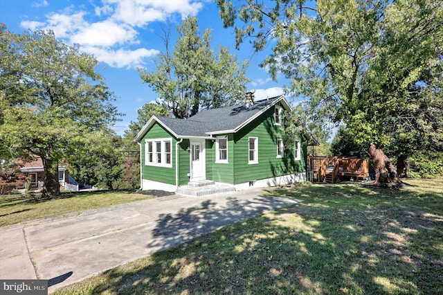 bungalow with a deck and a front lawn