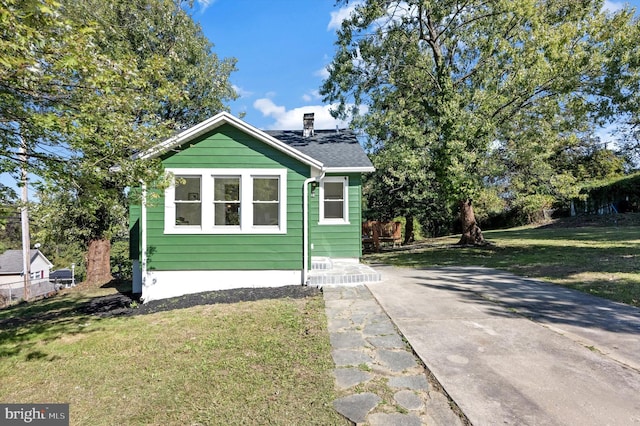 view of property exterior featuring a patio area and a lawn