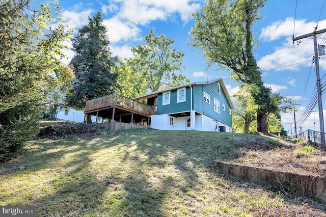 back of house featuring a deck and a yard