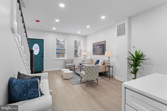 living area featuring visible vents, stairs, light wood-type flooring, a wealth of natural light, and recessed lighting