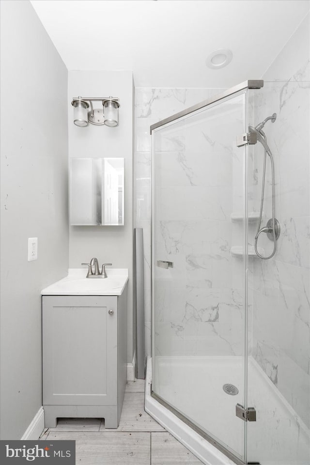 bathroom with vanity and a shower with door