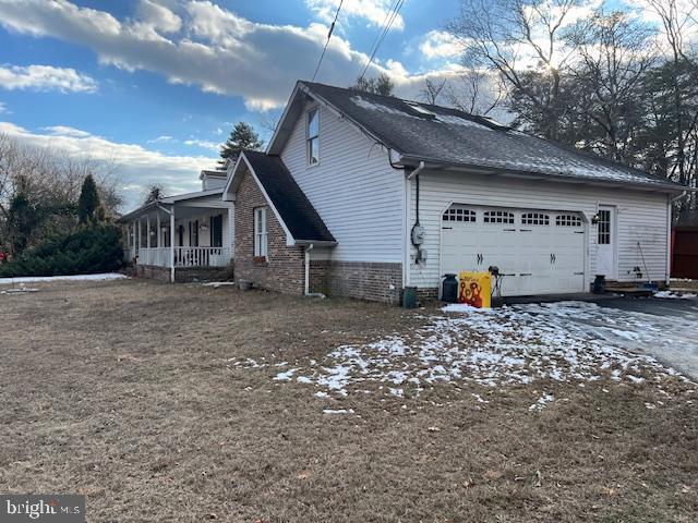 view of side of home with a porch and a garage