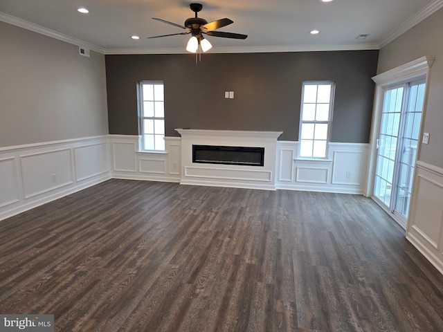 unfurnished living room featuring dark wood finished floors, plenty of natural light, visible vents, and a glass covered fireplace